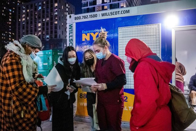People check their rapid COVID-19 test results outside of a testing site on the Lower East Side.